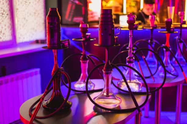 Shisha lounge Nijmegen with colorful hookahs and vibrant lighting near Waalkade.
